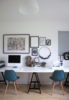 a white table topped with two blue chairs next to a laptop computer