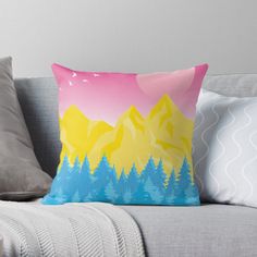 a couch with a pillow on it that has mountains and pine trees painted on it