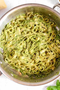 pasta with pesto and parsley in a silver bowl on a white table top