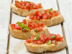 four pieces of bread topped with tomatoes and basil