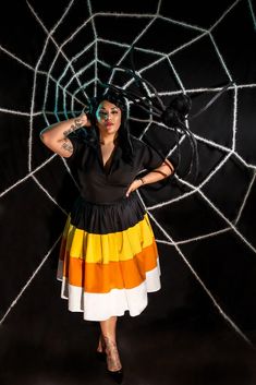 a woman is posing in front of a spider web