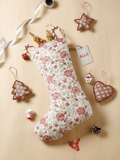 a stocking filled with christmas ornaments on top of a beige table next to other decorations