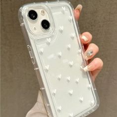 a woman holding up a clear case with hearts on the front and back of it