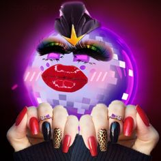 a woman's hands with red and black nail polish holding up her face in front of a disco ball