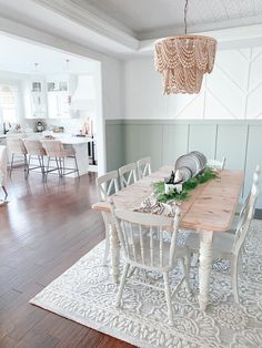 a dining room table with chairs and a chandelier hanging from the ceiling