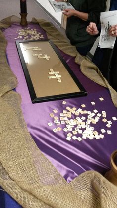 two people standing at a table with some type of cross on it