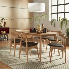 a dining room table with chairs and a rug on the floor in front of it