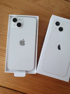 two new iphones in their boxes on a table