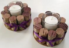 two wine cork candle holders with candles in them