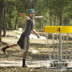 a man is throwing a frisbee in the woods