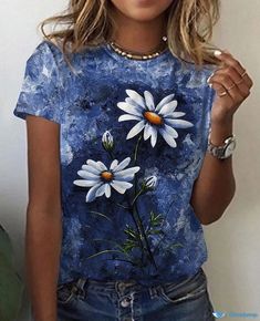 a woman wearing a blue shirt with white daisies on it