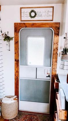 a white door in a room with a rug on the floor and plants hanging above it