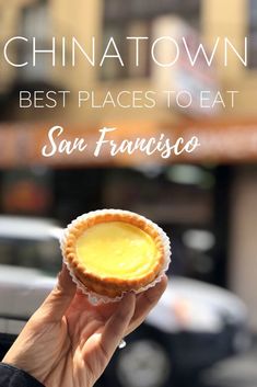 a person holding up a small pastry in front of a building with the words chinatown best places to eat san francisco