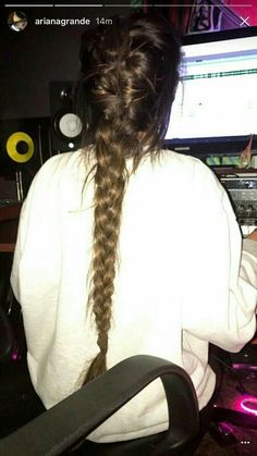 a woman with long hair sitting in front of a computer