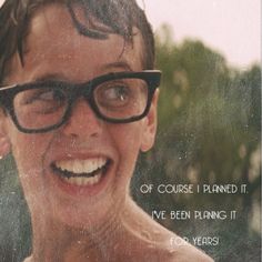 a young man with glasses is smiling for the camera and has an ad in front of him