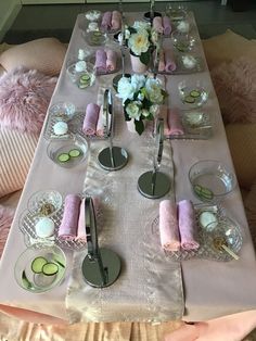 a long table is set with pink napkins and silver utensils on it