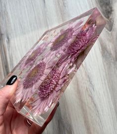 a hand holding a clear case with purple flowers on it