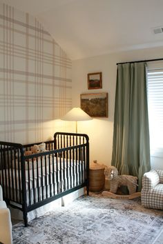 a baby's crib in the corner of a room with two lamps on either side