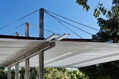 an outdoor covered patio area with trees and blue sky in the backgrouds