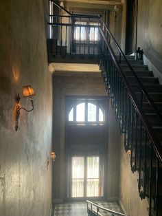 the stairs lead up to an open window in a building with wrought iron railings