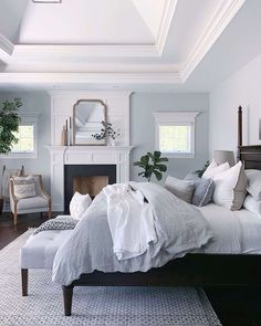 a bedroom with a bed, chair and fireplace in it's centerpieces