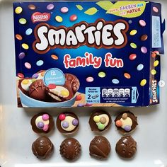 a box of smarties family fun chocolates on a plate with candy candies