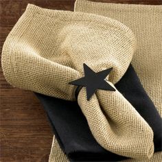 a black and white star is on top of a tan cloth with a black leather napkin