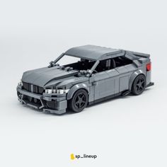 a toy car made out of legos on a white surface with the hood up