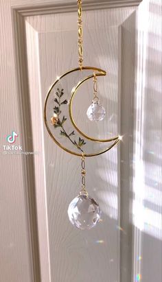 a sun catcher hanging from the side of a door with a crescent and flowers on it