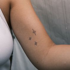 a woman's arm with three small stars on the left side of her arm