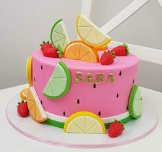 a cake decorated with fruit and the name sara