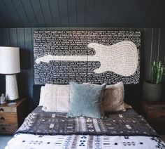 a bed with pillows and a painting on the wall above it in a room that has dark wood paneling