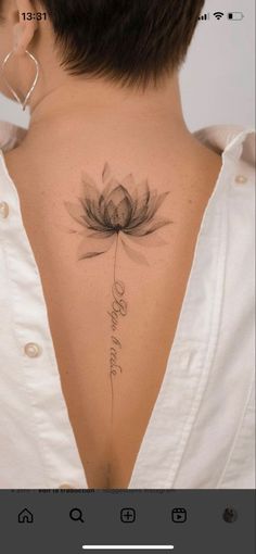 the back of a woman's neck with a lotus tattoo on it