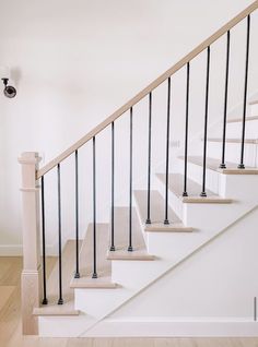 a white staircase with black railing and handrails