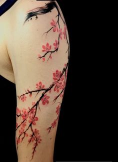 the back of a woman's shoulder with pink flowers on it and black background