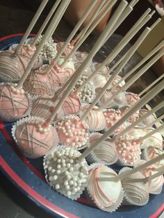 there are many heart shaped chocolates on the plate with sticks sticking out of them