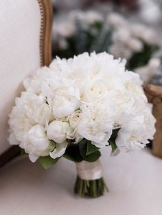 a bouquet of white flowers sitting on top of a chair