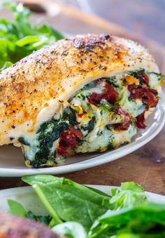 a close up of a plate of food with chicken and spinach on the side