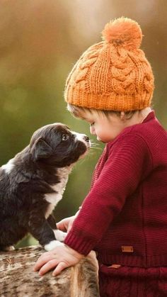 a little boy that is standing next to a dog