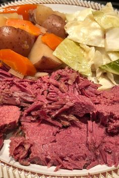 corned beef, cabbage, carrots and potatoes on a plate with lettuce