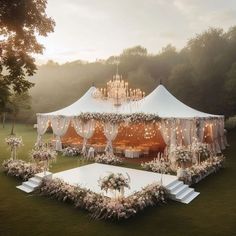 an outdoor wedding tent set up with flowers and chandeliers