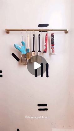 there is a clock made out of different tools hanging on the wall and in front of it