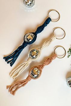 four different types of keychains and ornaments on a white surface with flowers in the background