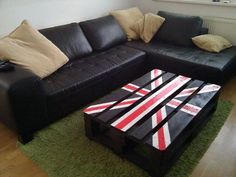 a living room with black leather couches and an union jack coffee table in the middle