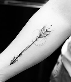 a black and white photo of a person's arm with an arrow tattoo on it