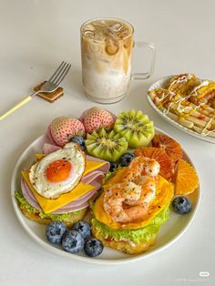 a white plate topped with lots of food next to a cup filled with ice cream