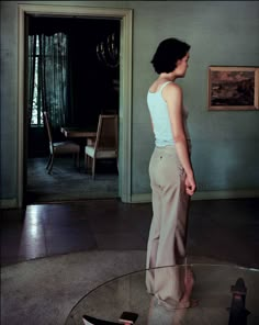 a woman standing in front of a glass table with a boat on top of it