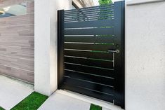 an entrance to a modern home with grass in the front yard