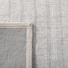 a white and gray rug with a square frame on it