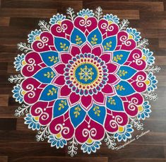 a colorful flower design painted on the floor in front of a wooden floor with wood planks